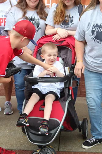 Jaxen Donnelly in red stroller surrounded by supporters